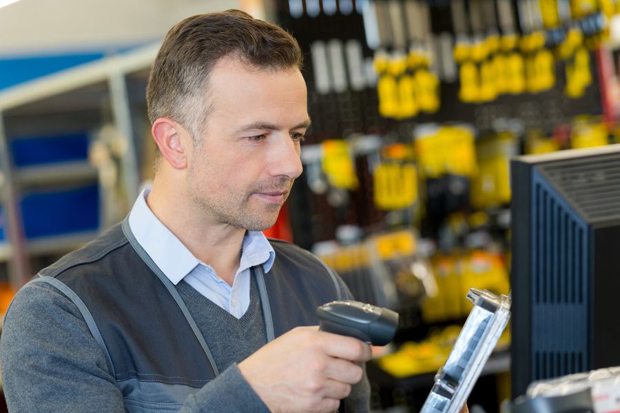 Staff member scanning stock at a trade counter